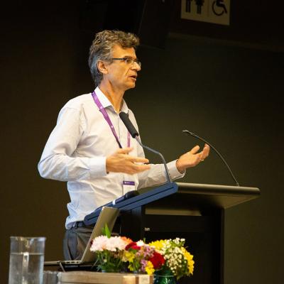 Professor Andrew Neal standing at podium lecturing on business psychology