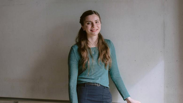 Laura Hondroudakis stands in front of a whiteboard smiling