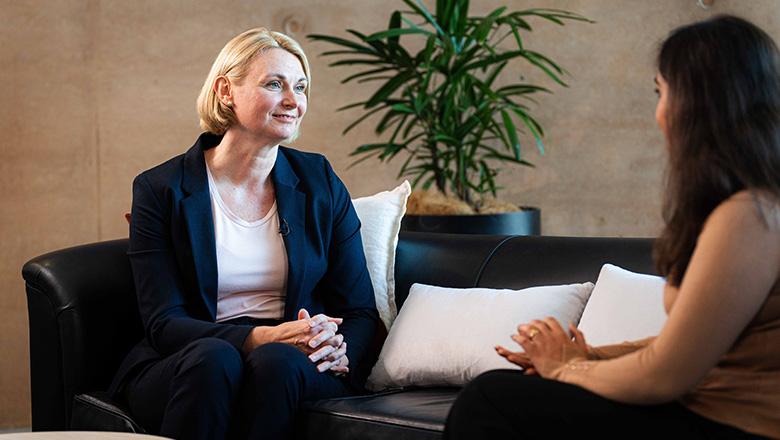 Lecturer in accounting, Debbie Jeffery, and Bachelor of Commerce student, Jaanvi, sit on a sofa talking
