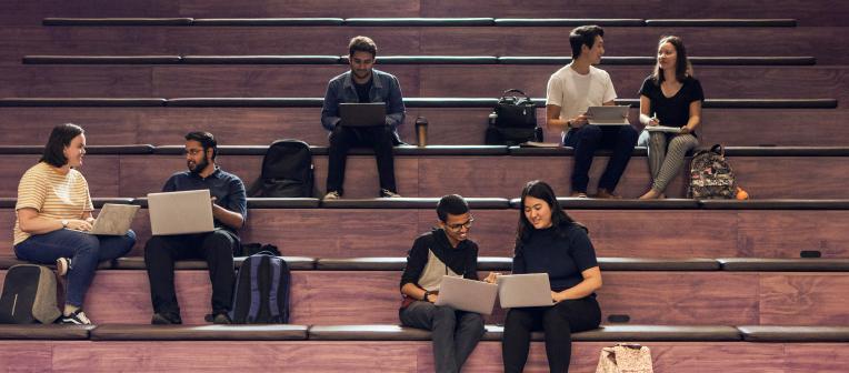 Students sitting on large steps in Library