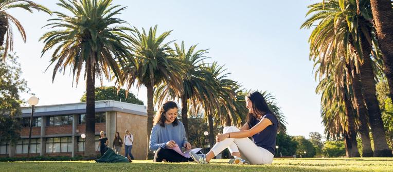 Two students sitting in the Gatton central walkway
