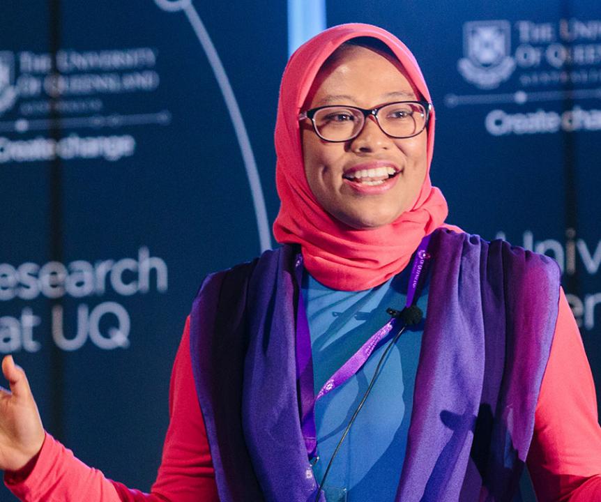 A UQ HDR student presents her research on stage during the Three-Minute Thesis competition.