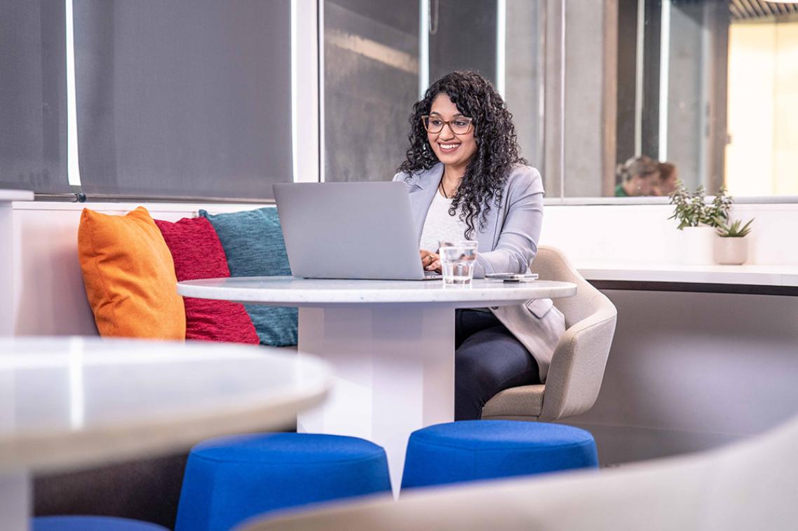 Woman sitting on couch and working on laptop