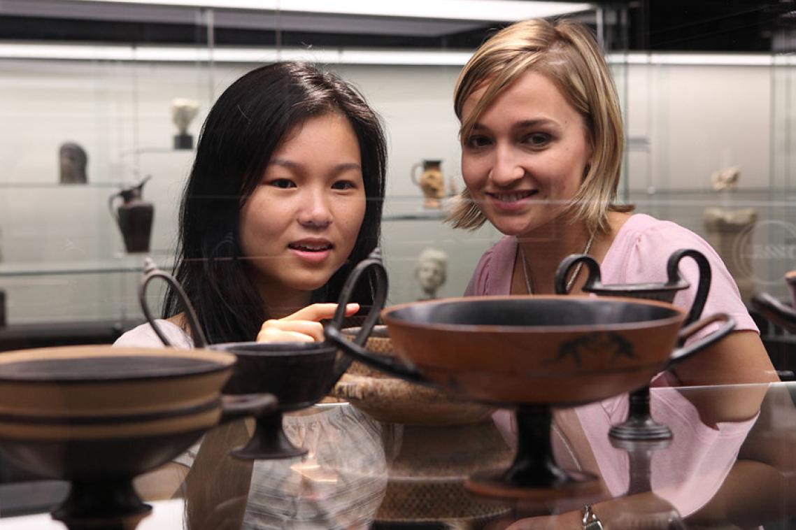 2 students looking at antiquities museum collection. 